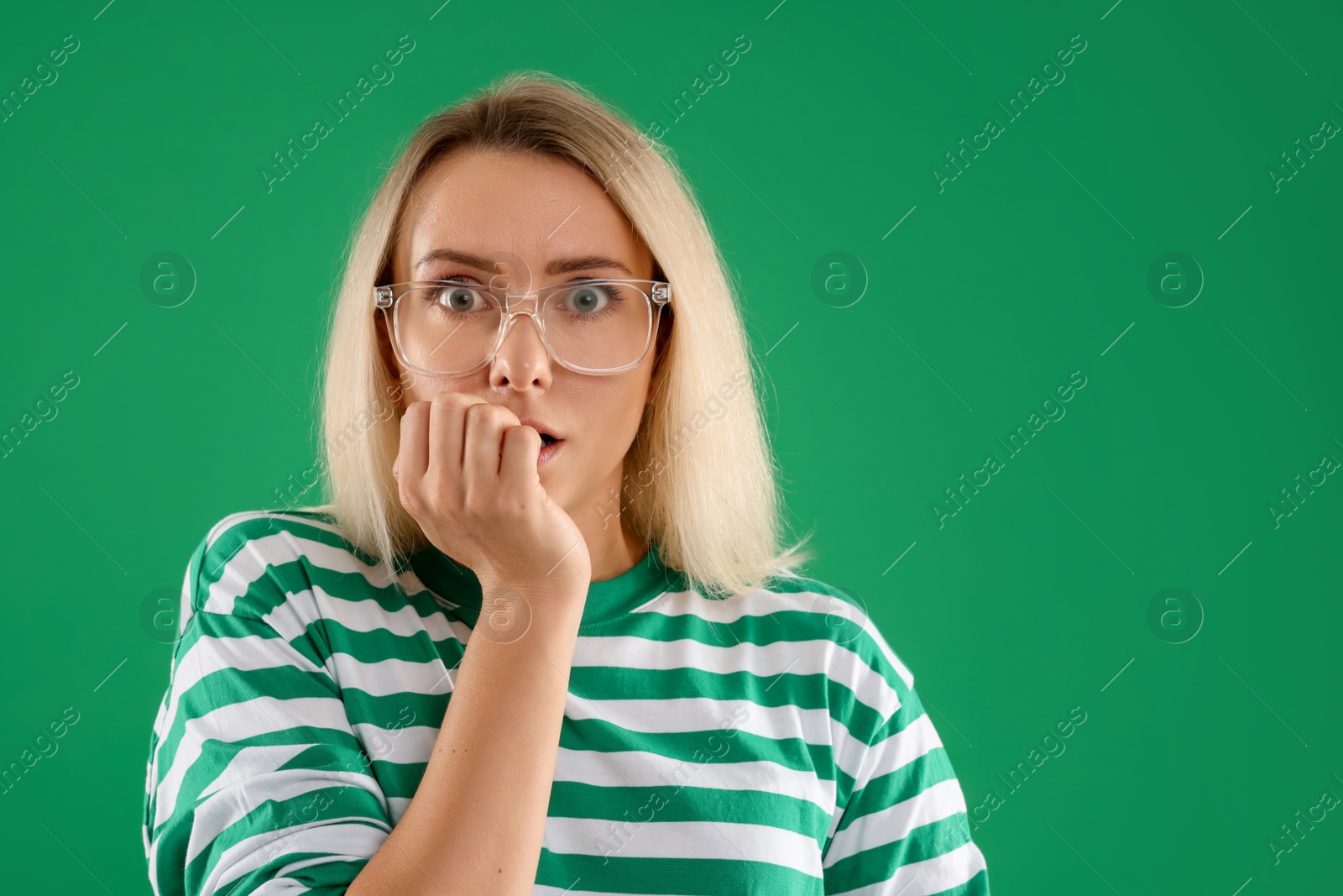 Photo of Portrait of scared woman on green background, space for text