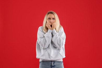 Portrait of scared woman on red background