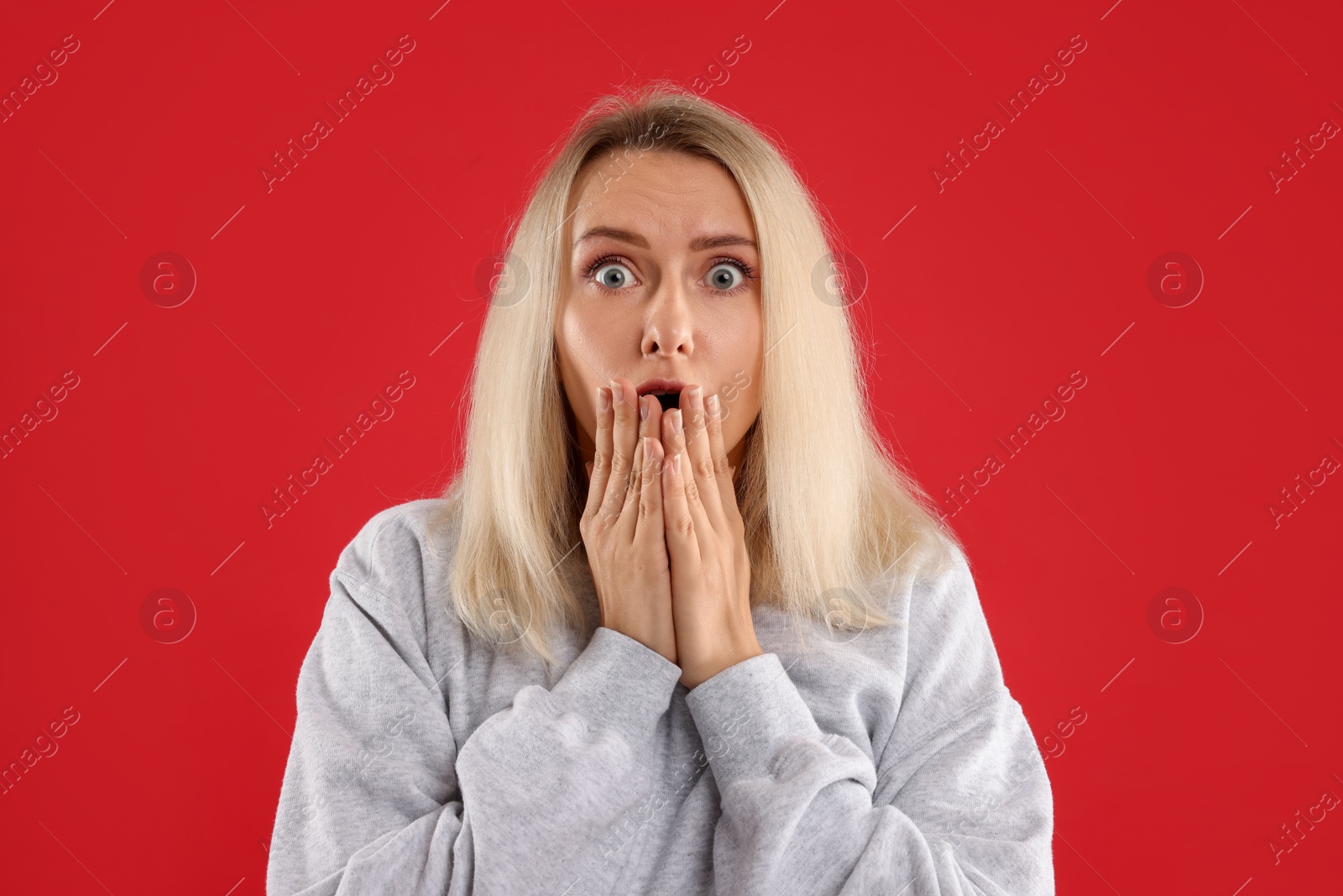 Photo of Portrait of scared woman on red background