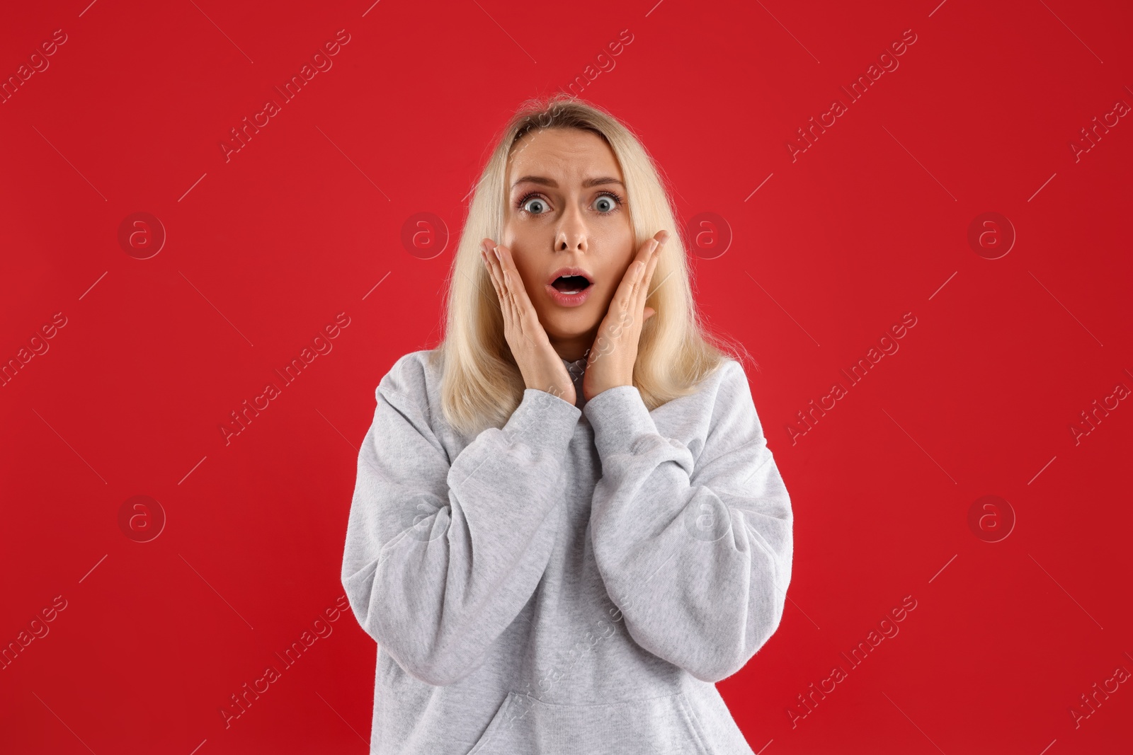 Photo of Portrait of scared woman on red background