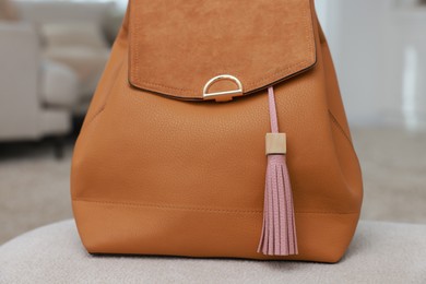 Photo of Backpack with pink leather keychain on soft surface indoors, closeup