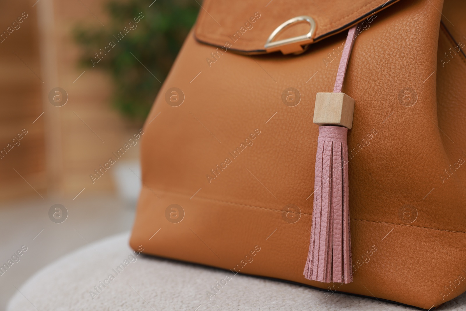 Photo of Backpack with pink leather keychain on soft surface indoors, closeup