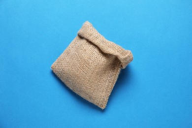 One burlap sack on light blue background, top view