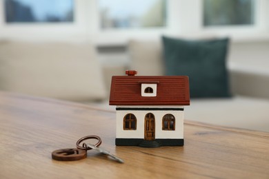 House model and key on wooden table indoors