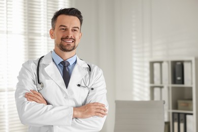 Smiling doctor with stethoscope in clinic, space for text