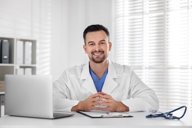 Smiling doctor working at table in clinic