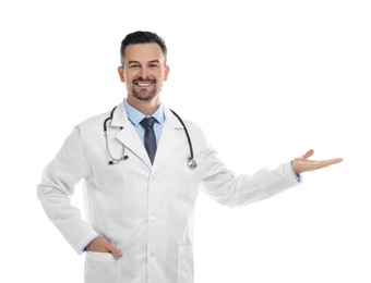 Smiling doctor with stethoscope pointing at something on white background