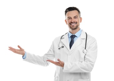 Photo of Smiling doctor with stethoscope pointing at something on white background