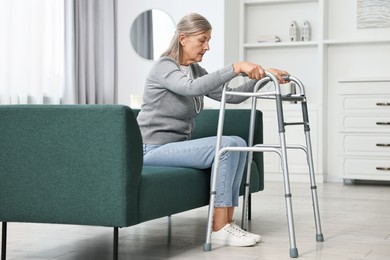 Photo of Senior woman with walking frame on sofa at home