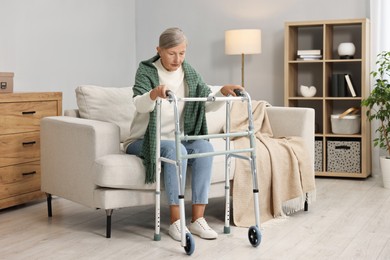 Photo of Senior woman with walking frame on sofa at home