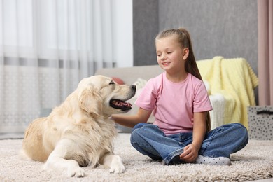 Photo of Girl with her cute Golden Retriever dog on rug at home