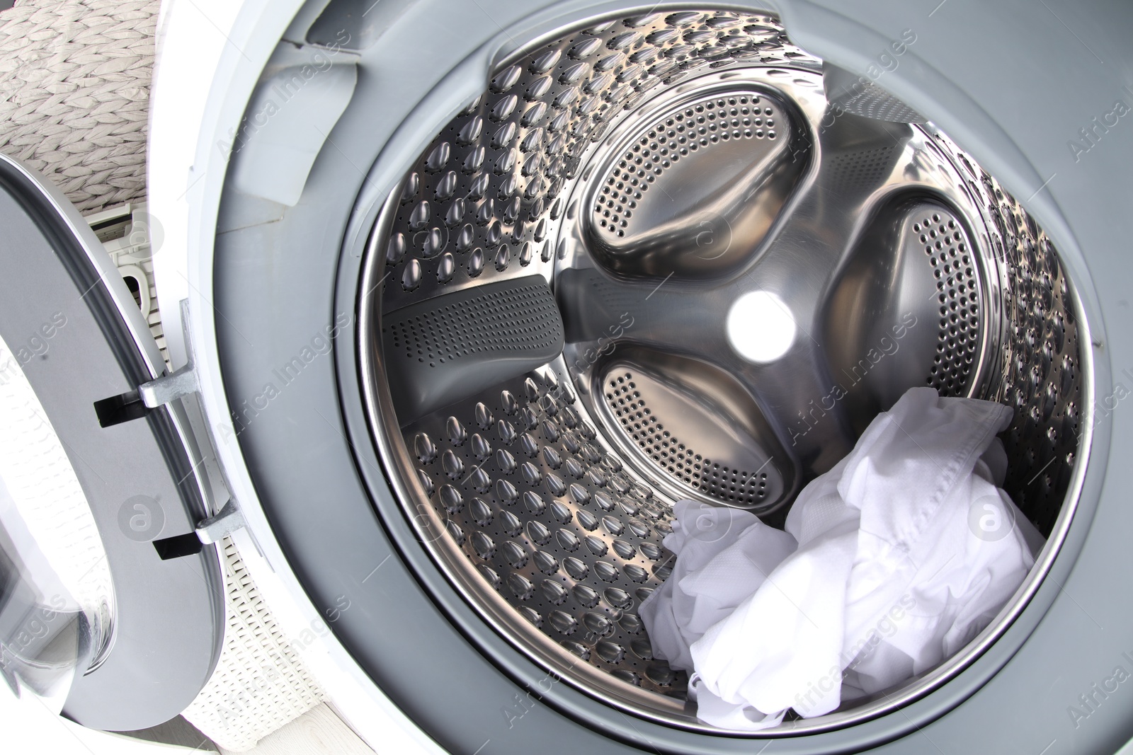 Photo of Washing machine with shirt as background, closeup