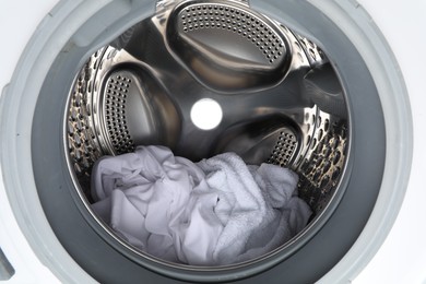 Photo of Washing machine with laundry as background, closeup