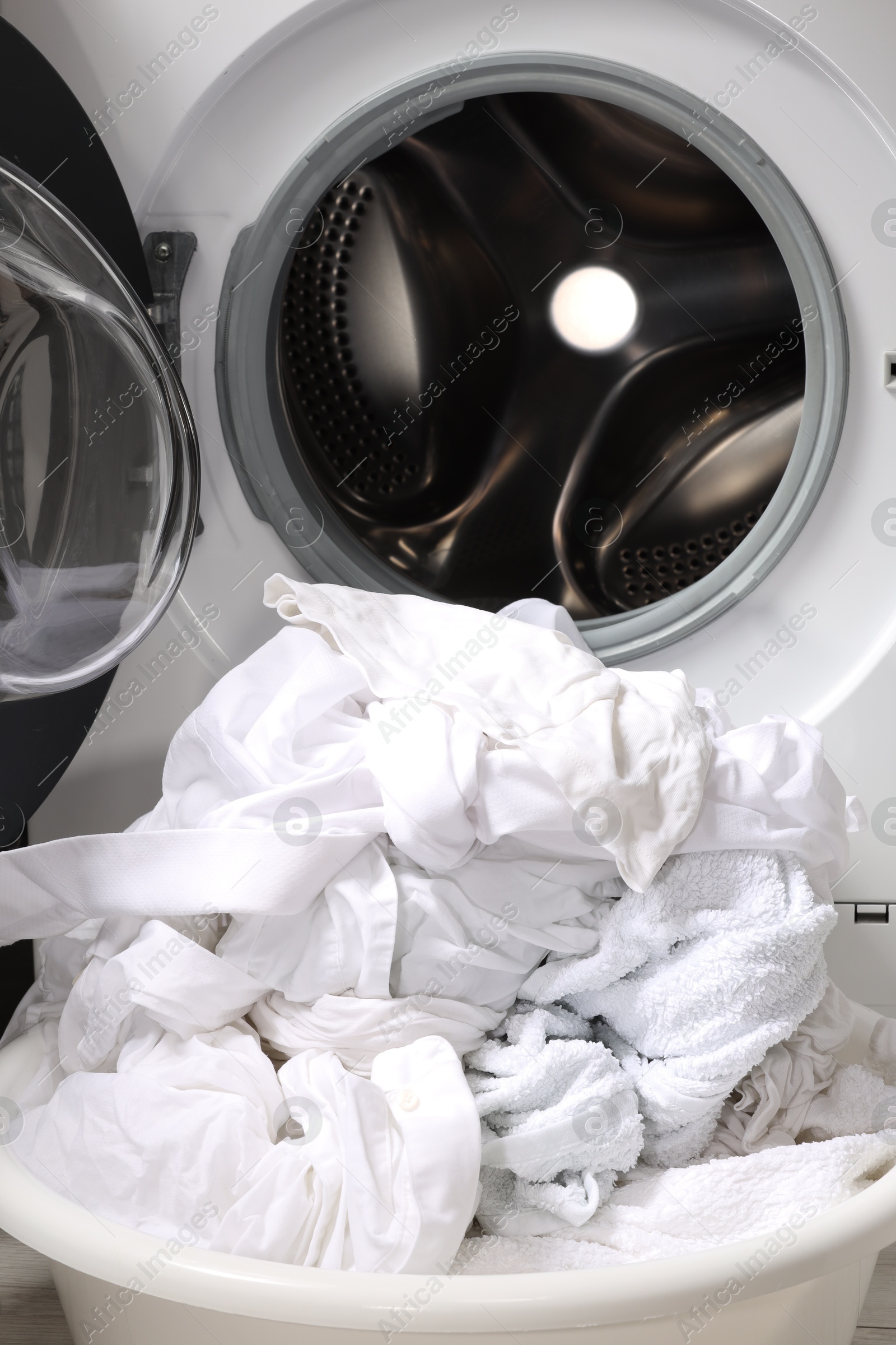 Photo of Basket with laundry near washing machine, closeup