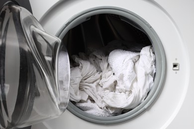 Open washing machine with clean clothes, closeup