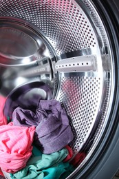 Washing machine with laundry as background, closeup