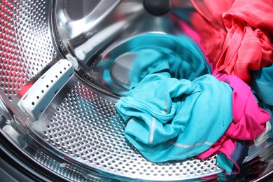 Washing machine with laundry as background, closeup