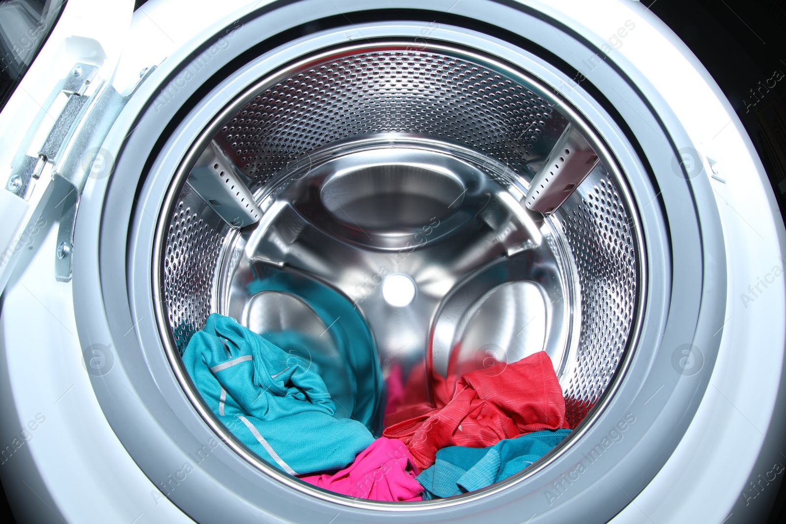 Photo of Washing machine with laundry as background, closeup