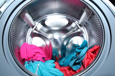 Photo of Washing machine with laundry as background, closeup