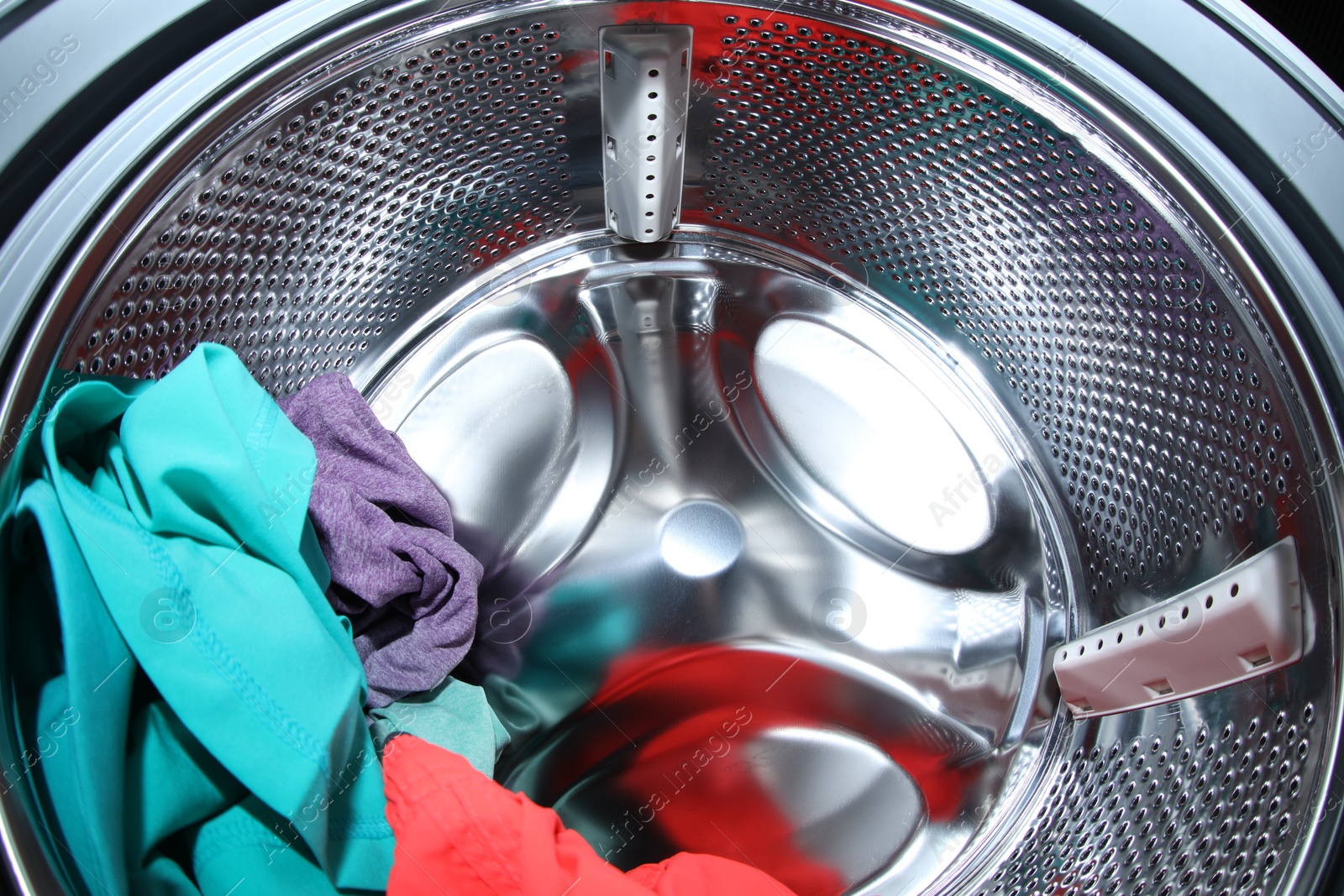 Photo of Washing machine with laundry as background, closeup