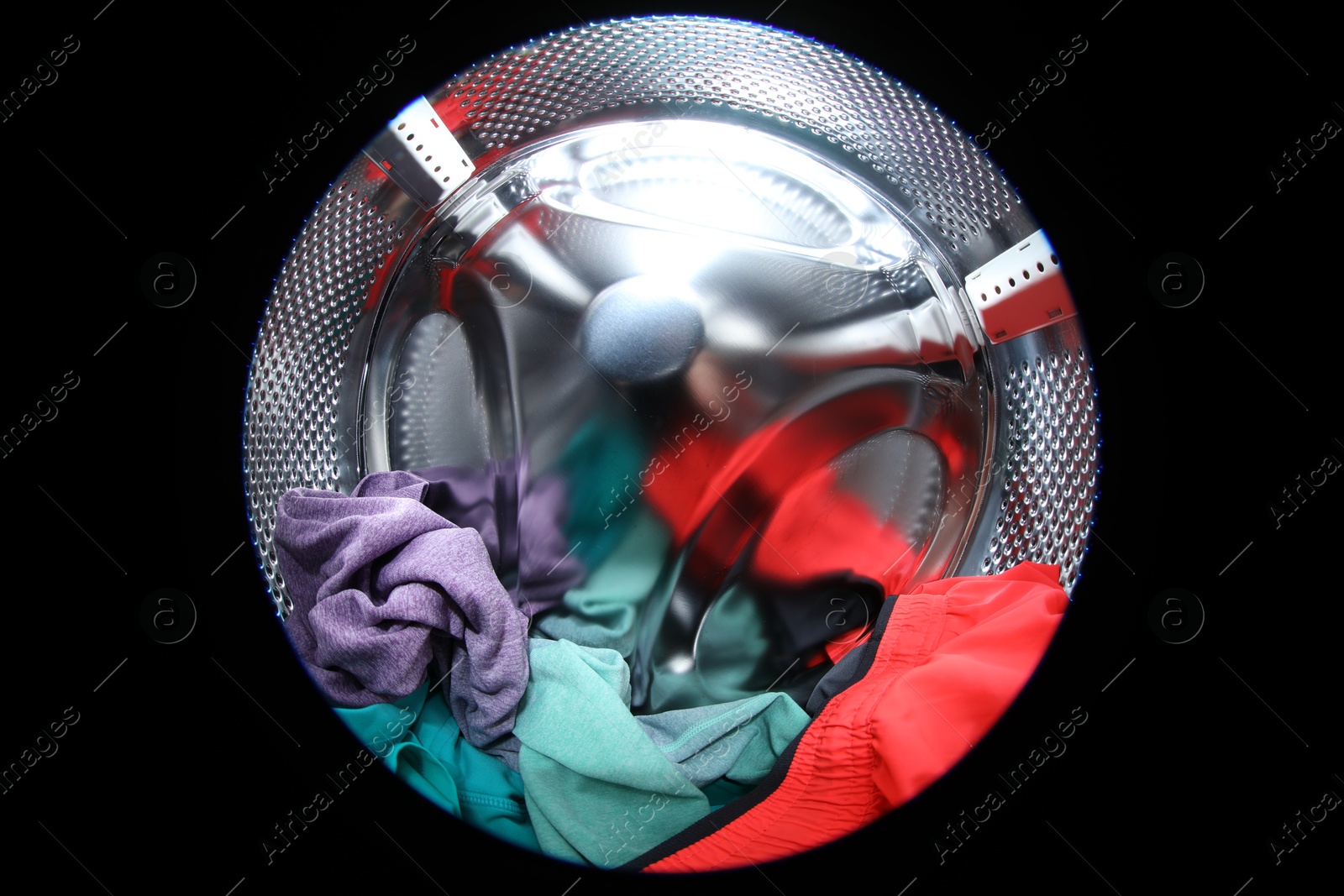 Photo of Washing machine with laundry as background, closeup