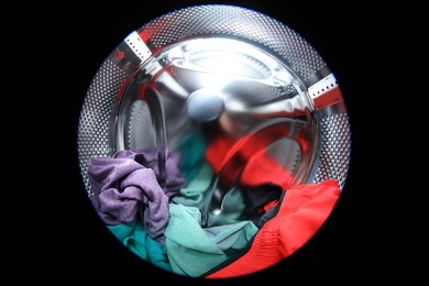 Washing machine with laundry as background, closeup