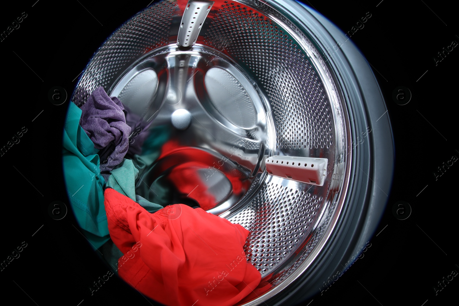 Photo of Washing machine with laundry as background, closeup