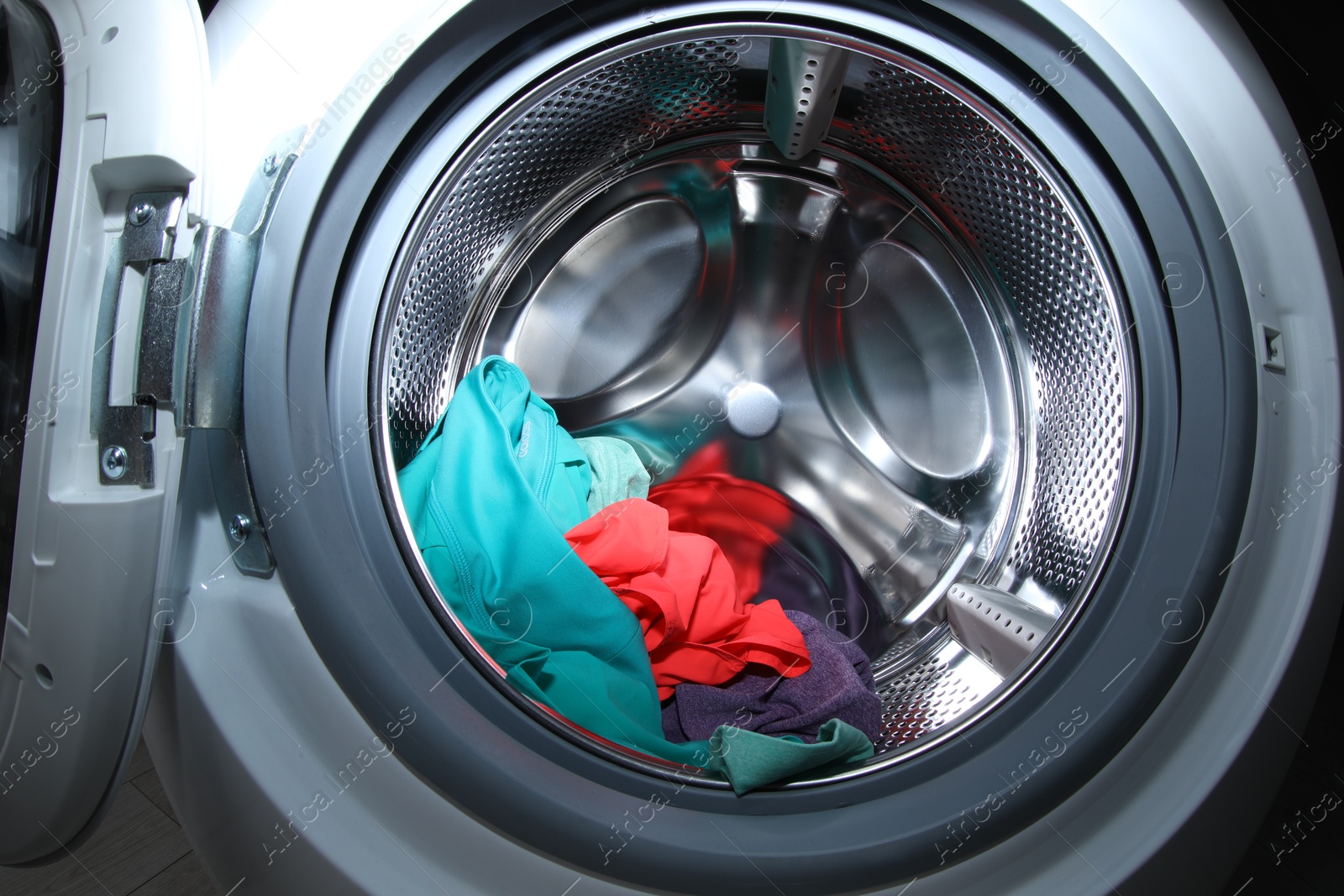 Photo of Washing machine with laundry as background, closeup