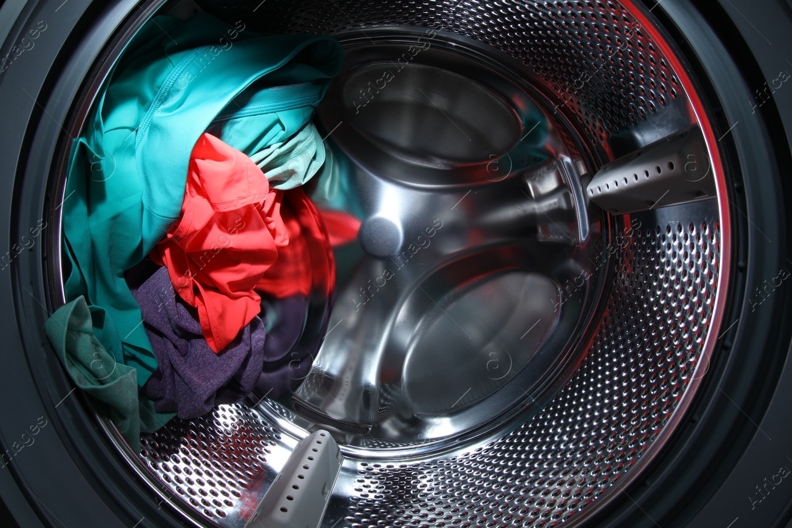 Photo of Washing machine with laundry as background, closeup