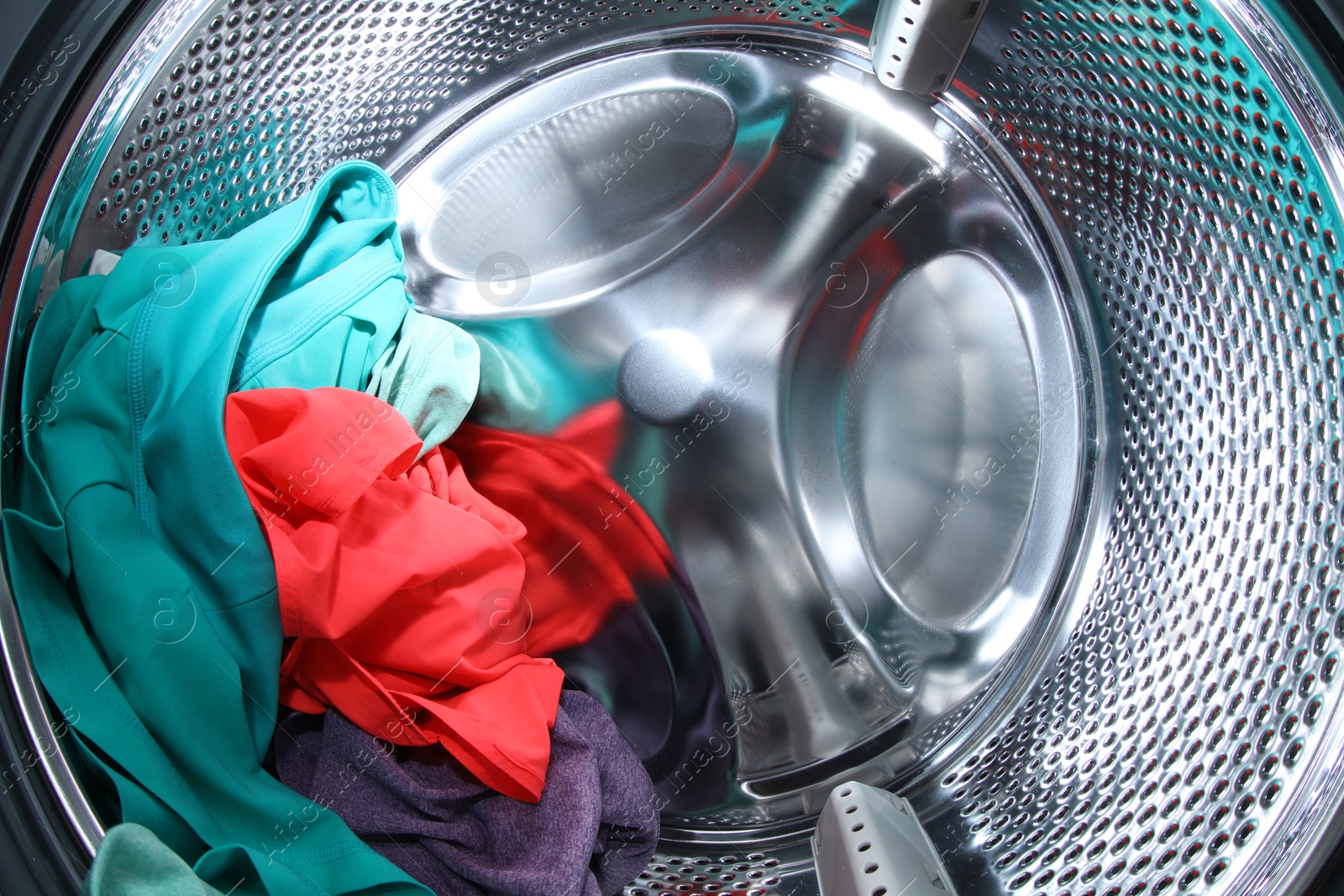 Photo of Washing machine with laundry as background, closeup