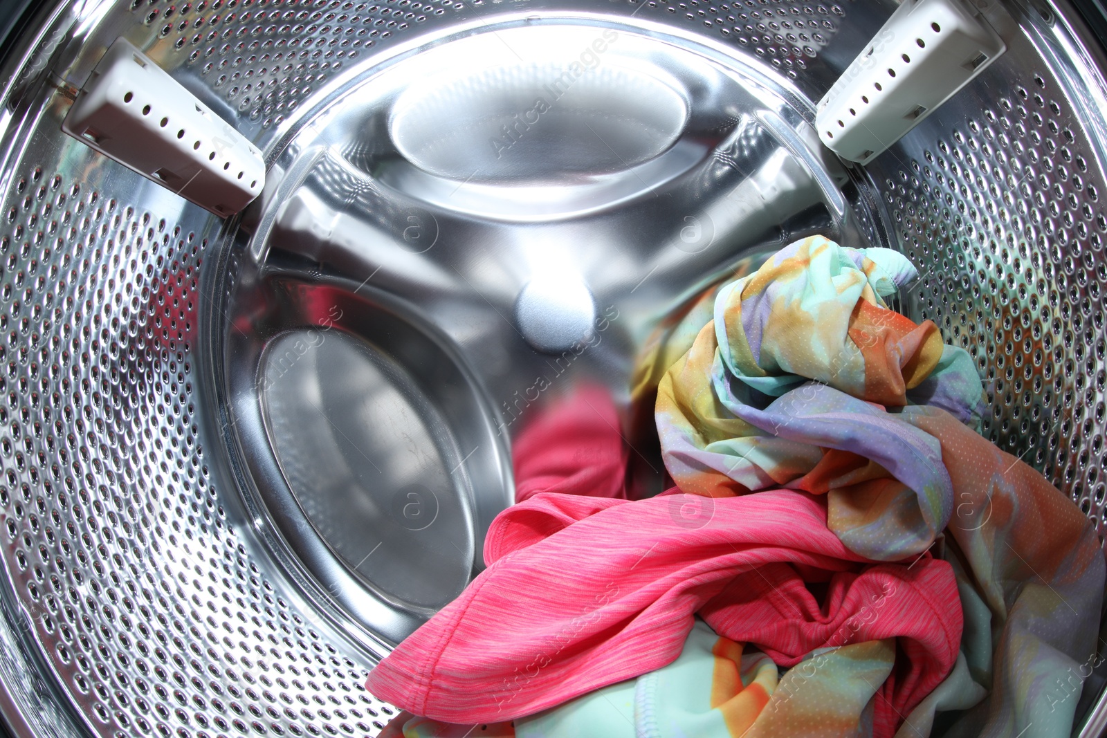 Photo of Washing machine with laundry as background, closeup