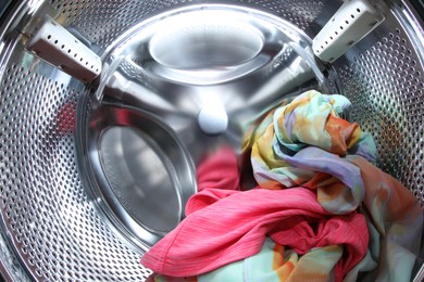 Photo of Washing machine with laundry as background, closeup