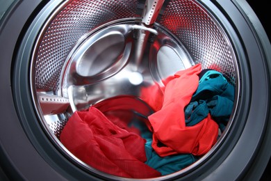 Washing machine with laundry as background, closeup