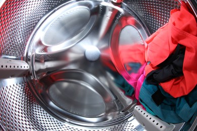 Washing machine with laundry as background, closeup