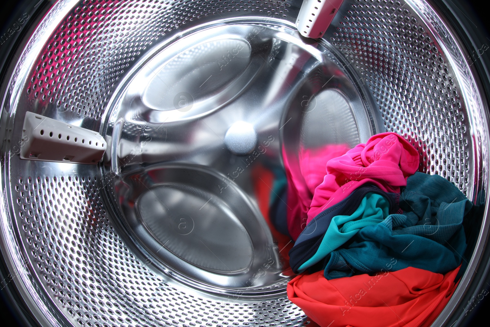 Photo of Washing machine with laundry as background, closeup