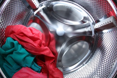 Photo of Washing machine with laundry as background, closeup