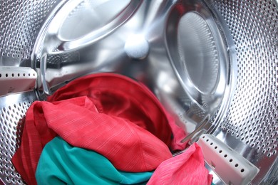 Photo of Washing machine with laundry as background, closeup