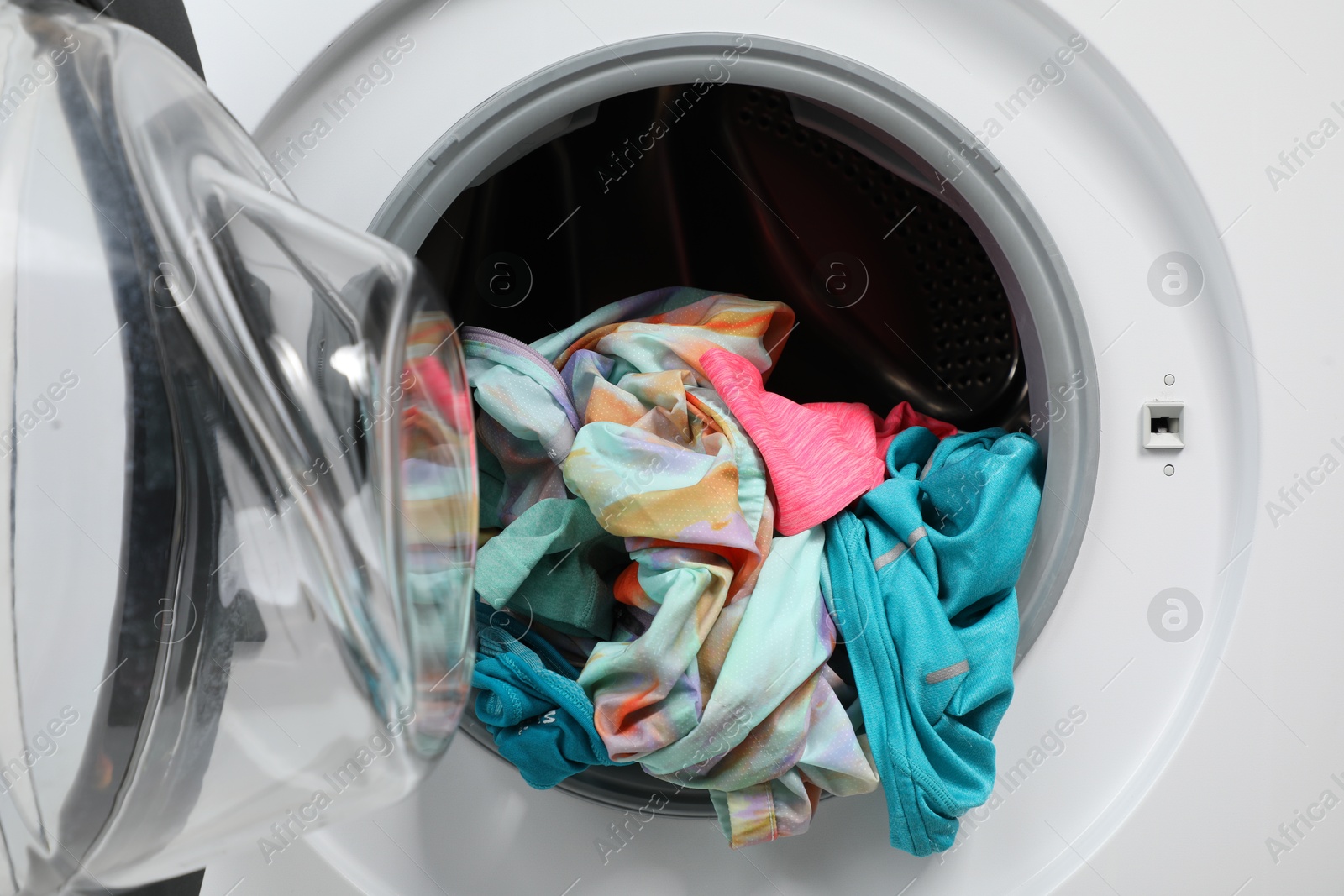 Photo of Washing machine with laundry as background, closeup