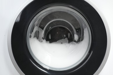 Washing machine with suds as background, closeup