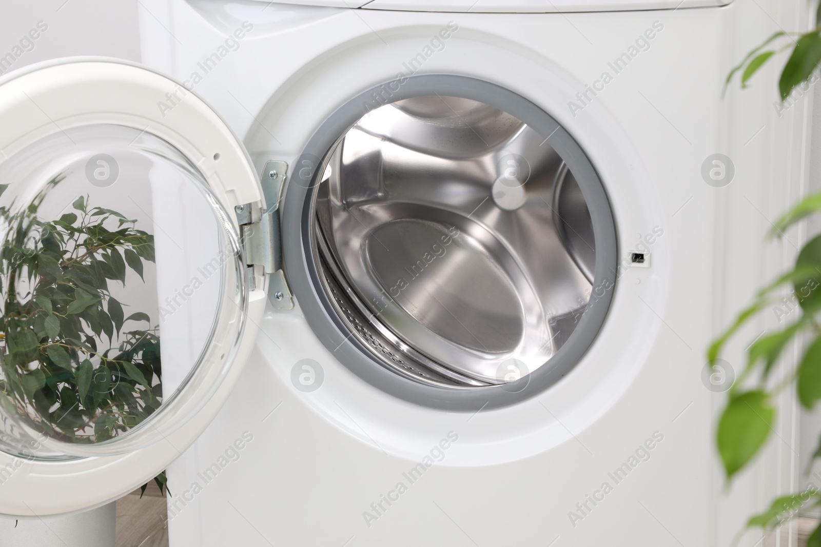 Photo of Washing machine with empty drum indoors, closeup