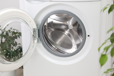 Washing machine with empty drum indoors, closeup