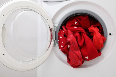 Washing machine with laundry near light wall, closeup