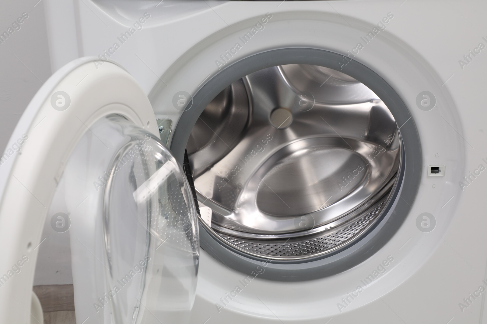 Photo of Washing machine with empty drum as background, closeup