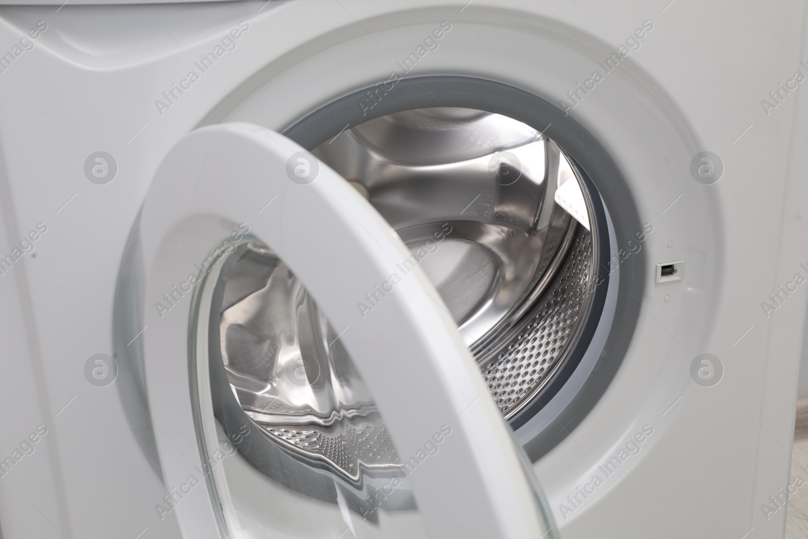 Photo of Washing machine with empty drum as background, closeup