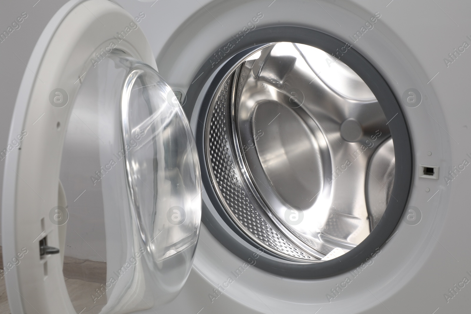 Photo of Washing machine with empty drum as background, closeup