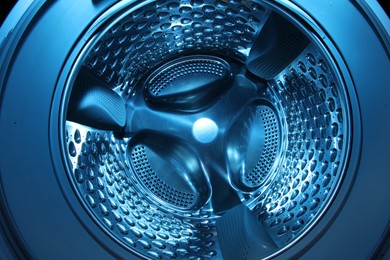 Washing machine with empty drum as background, closeup