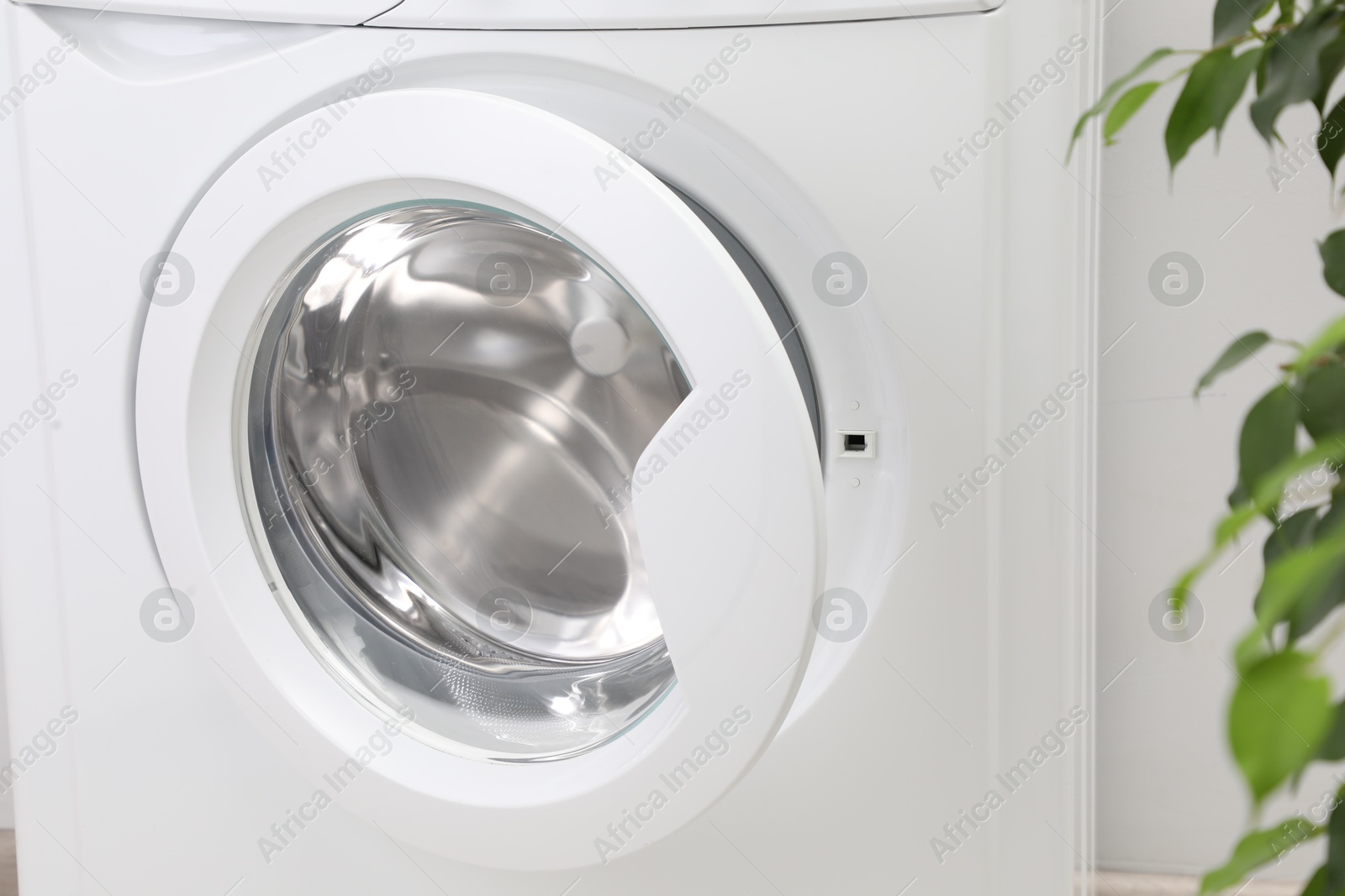 Photo of Washing machine with empty drum indoors, closeup