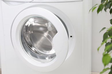 Washing machine with empty drum indoors, closeup