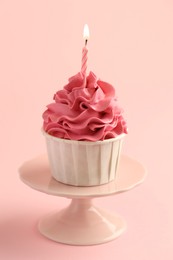 Photo of Tasty cupcake with burning candle on pink background