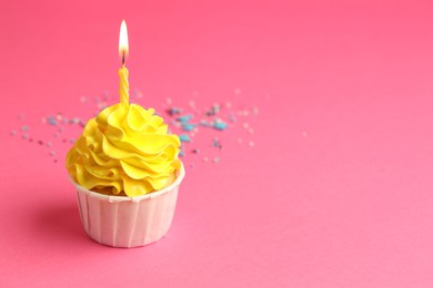 Photo of Tasty cupcake with burning candle on pink background, space for text